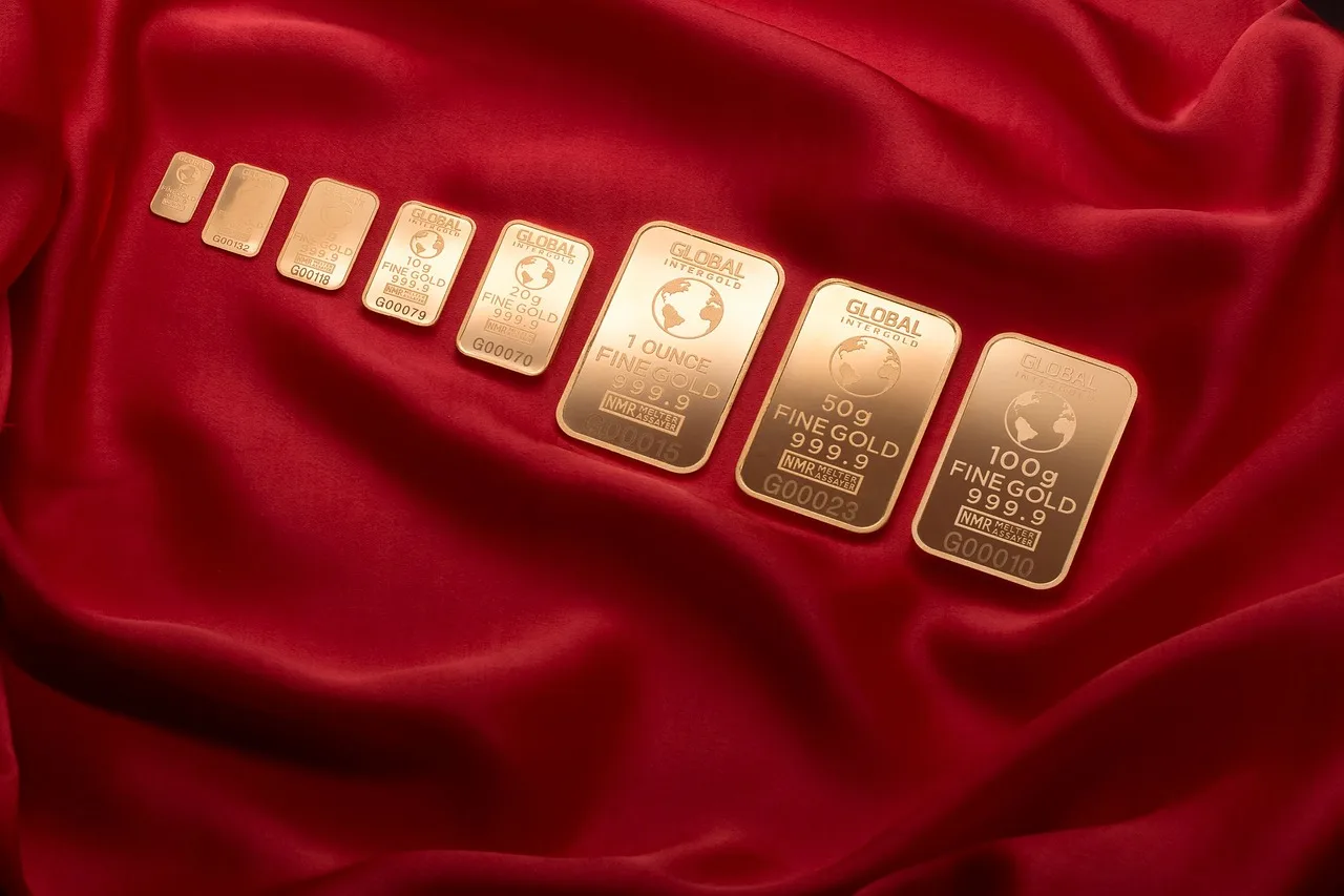 Immagine di lingotti d'oro con un grafico che mostra la quotazione attuale di 100 grammi di oro.